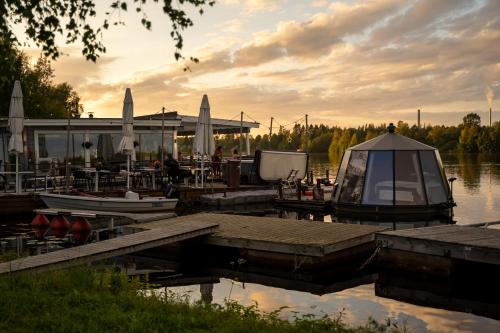 a dock with a boat on a body of water at Koivuranta Igloos in Oulu