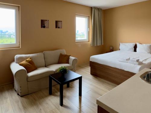 a hotel room with a bed and a couch at AirportStay bg - free shuttle and own parking in Sofia