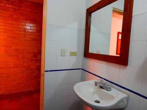 un bagno con lavandino e specchio di Hotel Castillo Real ad Armenia