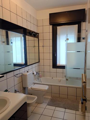a bathroom with a toilet and a tub and a sink at Bright apartment between Como and Milan in Lurago Marinone