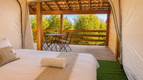 a bed in a tent with a table on a patio at Marina Park in Vama Veche