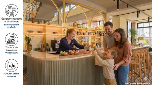 a family standing at a bar in a kitchen at Kyriad Prestige Compiègne Hotel & Spa in Compiègne