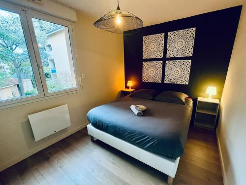 a bedroom with a bed and two windows at L'Écrin du Petit Prince SoCozy in Toulouse
