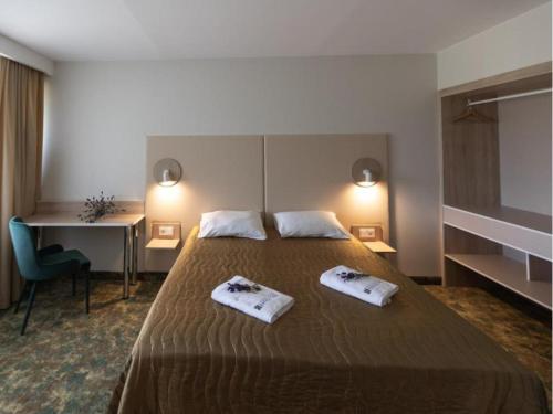 ein Hotelzimmer mit einem Bett, auf dem zwei Handtücher liegen in der Unterkunft Health & Wellness Center Energetikas in Šventoji