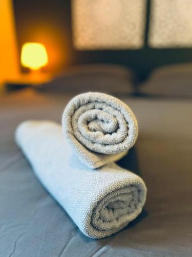 a rolled up towel sitting on top of a bed at L'Écrin du Petit Prince SoCozy in Toulouse