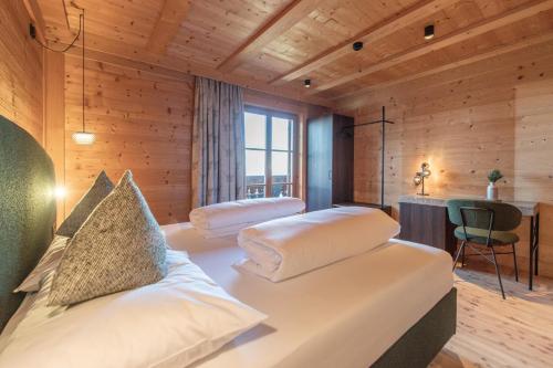 a bedroom with two beds in a room with wooden walls at HOFERALPL hike-in-mountainhouse in Bagni di Lavina Bianca