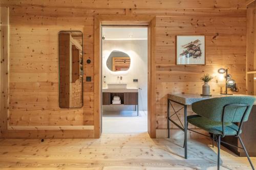 a bathroom with wooden walls and a table and a mirror at HOFERALPL hike-in-mountainhouse in Bagni di Lavina Bianca