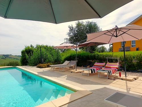 a swimming pool with chairs and umbrellas and a swimming pool at Villa Ferranti Abruzzo in Montefino