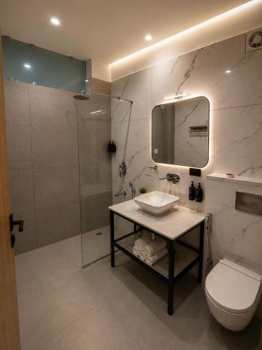 a bathroom with a toilet and a sink and a shower at Heritage Resort's Jageshwar in Jageshwar