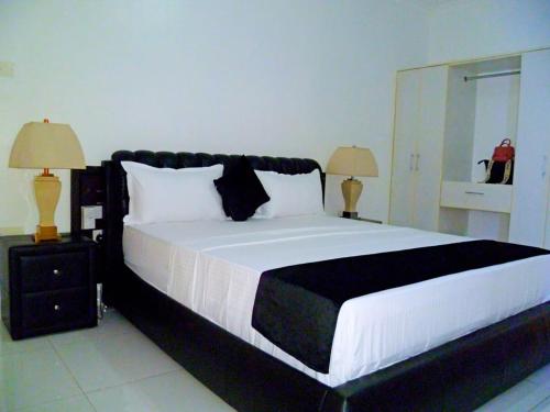a bedroom with a black and white bed with two lamps at Rosa Mystica Diani Bnb in Ukunda Airport