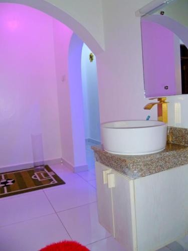 a bathroom with a sink and a purple room at Rosa Mystica Diani Bnb in Ukunda Airport