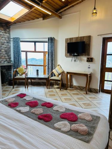 a living room with a large bed with a rug at frozen valley in Mukteshwar