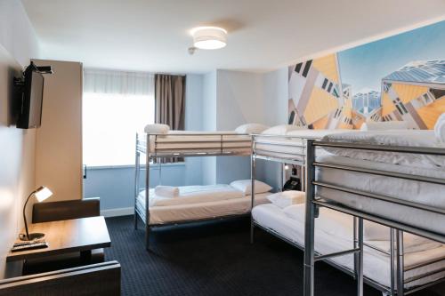 a dorm room with three bunk beds in it at Rotterdam Teleport Hostel in Rotterdam