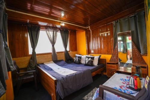 a bedroom with a bed and a chair in a boat at Dixit Homestaay & Hostel in Darjeeling