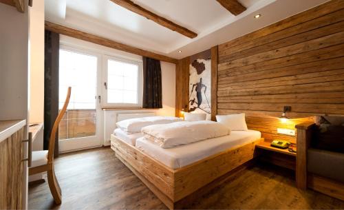 a bedroom with two beds and a wooden wall at Ferienhaus Alpina in Kals am Großglockner