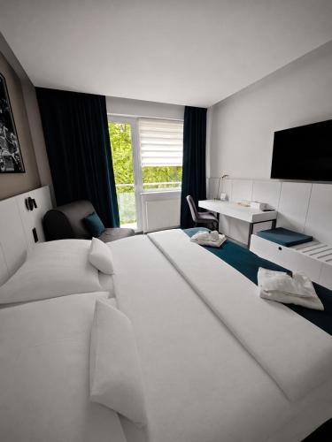 a hotel room with two beds and a television at Horský hotel Montana in Špindlerův Mlýn