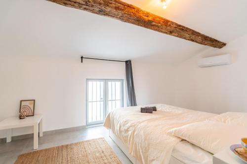 a white bedroom with a bed and a window at Secret Garden in Vias