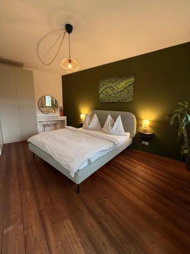 a bedroom with a bed and a green wall at FEWO Studio7 in Vorderelsenwang