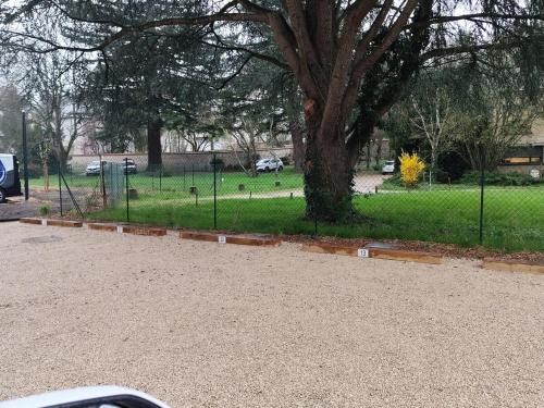 a park with a tree and a fence at Studio Ty Lys lumineux, climatisé, balcon, parking gratuit Classé 3 étoiles in Blois