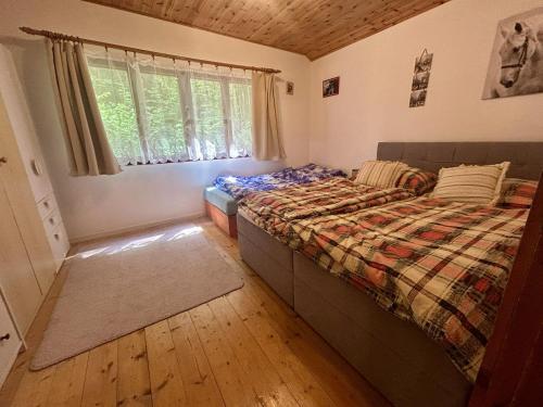 a bedroom with a bed with a comforter and a window at U čerchovského pramene in Pec