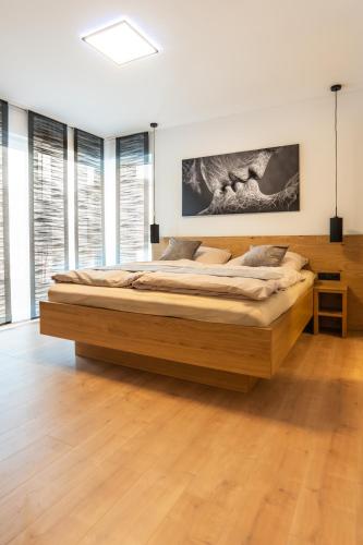 a bedroom with a large wooden bed in a room with windows at Chalet Maier in Landschach