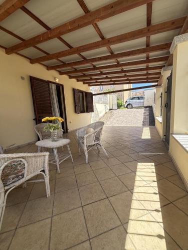 a patio with chairs and a table and a roof at Leoni's House in Calasetta