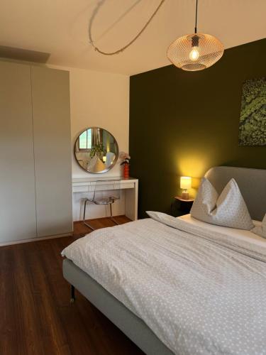 a bedroom with a large bed and a mirror at FEWO Studio7 in Vorderelsenwang