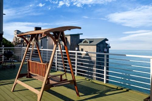 a wooden swing sitting on top of a balcony with the ocean at Samcheok eastocean in Samcheok