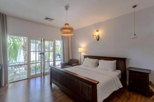 a bedroom with a bed and a chair in it at Green Gallery Beach Boutique Hotel in Hua Hin
