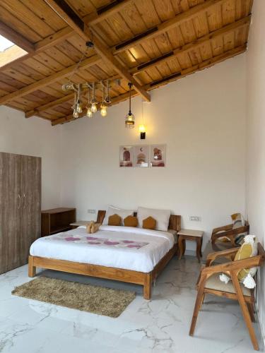 a bedroom with a large bed and a wooden ceiling at frozen valley in Mukteshwar