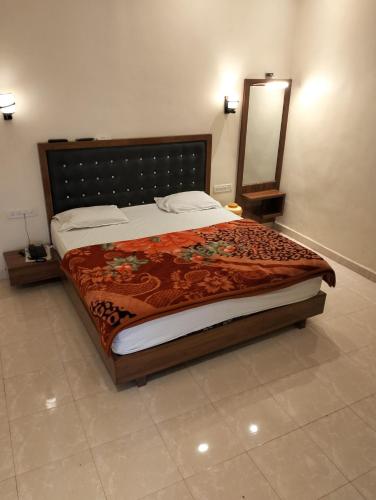a bedroom with a large bed with a large mirror at New Krishna Hotel Matheran in Matheran