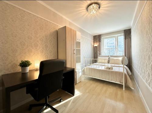 a bedroom with a desk and a baby crib at Central Warsaw Apartment with Pool & Sauna in Warsaw