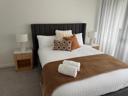 a bedroom with a large bed with two towels on it at 2BR Elevated Living Suite in Campbell