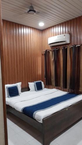 a large bed in a room with wooden walls at hotel sooryoday j in Varanasi