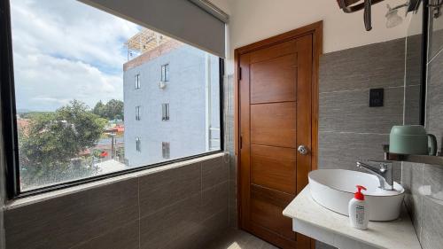 a bathroom with a sink and a large window at Nắng Hotel in Cẩm Mỹ