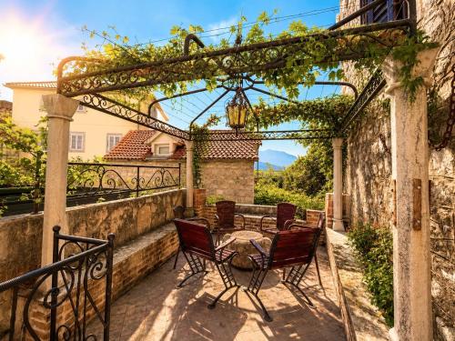 a patio with a table and chairs under a pergola at Hidden Garden Stone House Private Romantic Retreat in Budva Old Town in Budva