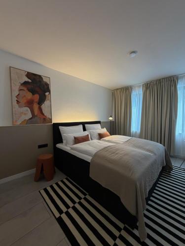 a bedroom with a large bed and a painting on the wall at MY STAY - Smart Hotel in Mönchengladbach