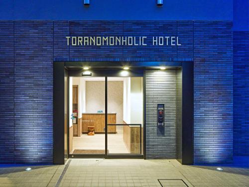 a blue brick building with the entrance to aktivulic hotel at TORANOMONHOLIC Hotel in Tokyo