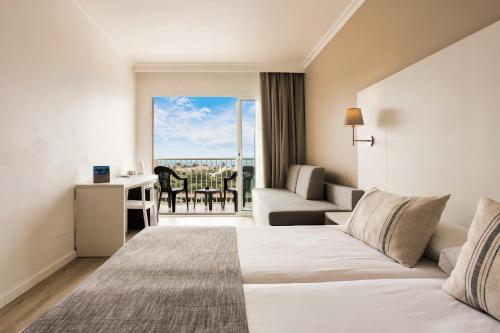a hotel room with a bed and a balcony at Minura Sur Menorca in Punta Prima
