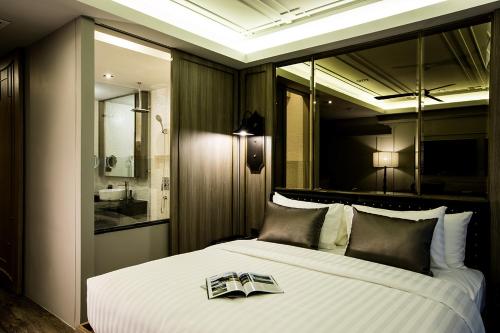 a bedroom with a large bed with a book on it at De Chai the Deco Chiang Mai - SHA Plus in Chiang Mai