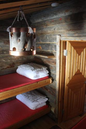 a cabin with two bunk beds and a pot on the wall at River Cabin Urpo in Inari