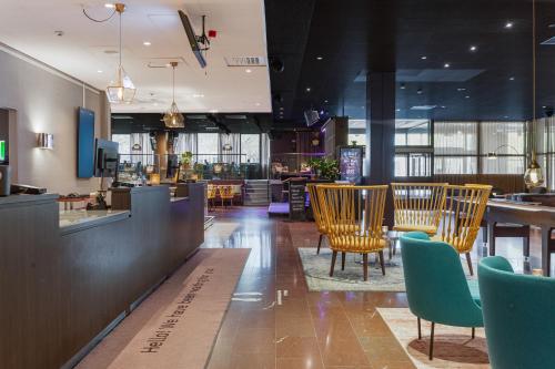 a restaurant with chairs and a bar in a building at Quality Hotel Sundsvall in Sundsvall