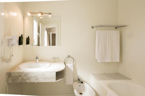 a white bathroom with a sink and a mirror at Minura Sur Menorca in Punta Prima