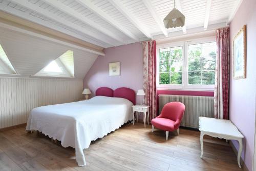 a bedroom with a white bed and two red chairs at La Bulle in Verton