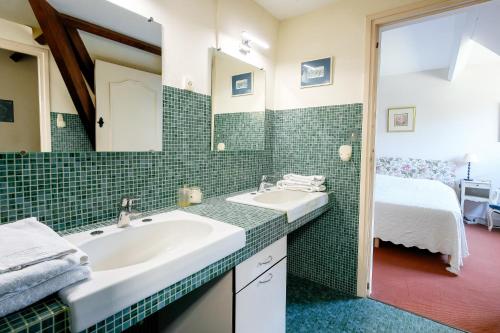 a bathroom with a sink and a mirror and a bed at La Bulle in Verton