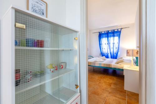 a bathroom with a glass shower door with a bedroom at Villa Rosa Sea View in Valledoria