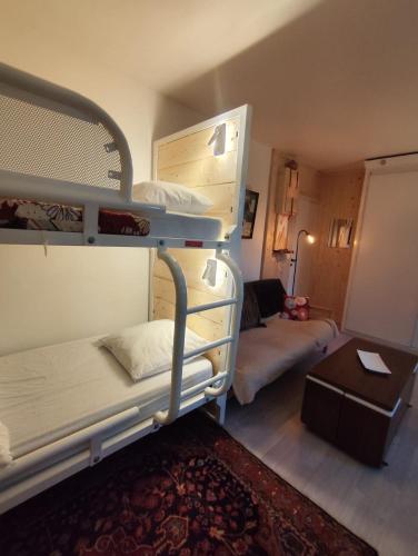 a room with two bunk beds and a living room at La Tanière in Ustou