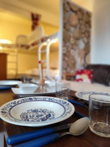 a wooden table with plates and spoons on it at La Tanière in Ustou