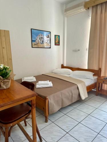 a bedroom with a bed and a table and a desk at OLGA STUDIOS in Olympic Beach