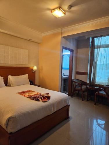 a bedroom with a bed and a desk and a window at C Fun Addis Hotel in Addis Ababa